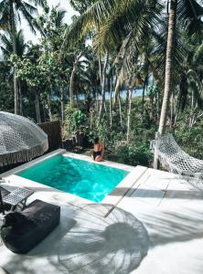 a woman sitting in a chair next to a swimming pool at Exotic Private Glamping in Nusa Penida