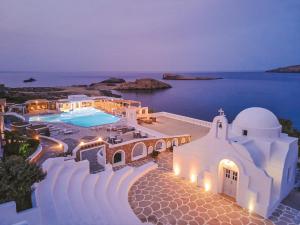 a view of a building with a pool at night at Mykonos Lolita, A Grecotel Resort to Live in Agios Sostis Mykonos
