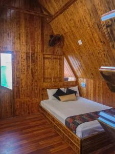 a bedroom with a bed in a wooden cabin at Arshinagar Shilpogram in Kolkata