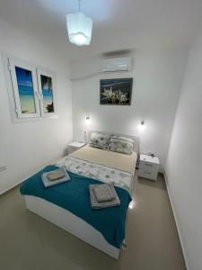 Un dormitorio con una cama con dos toallas encima. en BLUE apartment in 5* Ceasar Resort, en Trikomo
