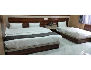 2 Betten in einem Hotelzimmer in der Unterkunft Hotel Shree Badri Valley, Badrinath in Badrīnāth