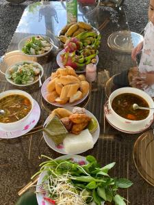 a table topped with plates of food and bowls of soup at Homestay tay in Xã Trảng Bôm