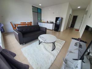 a living room with a couch and a table at Bunny Homestay 408 @ Roxy Apartment Kuching in Kuching