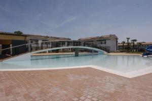 una piscina con un puente en un edificio en Nice three bedroom apartment close to the sea, en Bibione