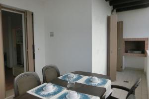 mesa de comedor con sillas y mantel azul y blanco en Nice three bedroom apartment close to the sea, en Bibione