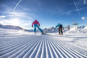two people are skiing down a snow covered slope at Ferienwohnung Sabine in Flattach