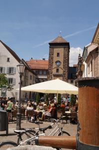 a group of people sitting at tables under an umbrella at Loft Style 3 Room Apartment + terrace in Villingen-Schwenningen