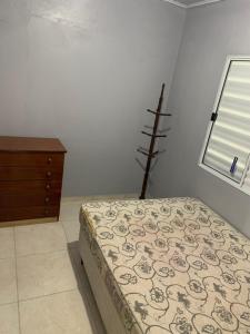 1 dormitorio con 1 cama, vestidor y ventana en Casa de Praia, en Tramandaí