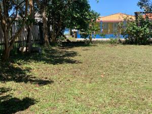 特拉曼達伊的住宿－Casa de Praia，一座有树木和草地的院子和栅栏