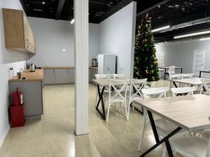a christmas tree in a room with tables and chairs at Hostel O2 in Almaty