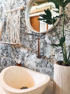a bathroom with a sink and a mirror and a plant at Exotic Private Glamping in Nusa Penida