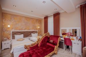 um quarto com uma cama grande e um sofá vermelho em HOTEL SILK ROAD EMPIRE SAMARKAND em Samarkand