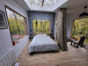 Un pat sau paturi într-o cameră la La maison dans l'arbre