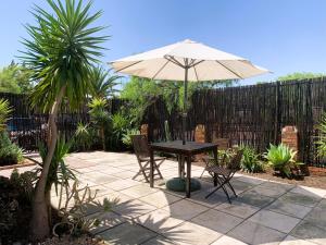 a table and chairs with an umbrella on a patio at Apartment with garden, and garage in Cape Town