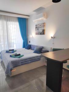 a bedroom with a bed and a desk in it at RELAX&DREAM apartment Long Beach in Saint Yeorgios