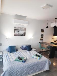 een slaapkamer met een bed met blauwe kussens en een bureau bij RELAX&DREAM apartment Long Beach in Saint Yeorgios