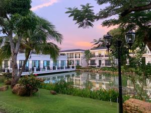 a resort with a pond in front of a building at DAD Resort Phú Quốc in Phú Quốc