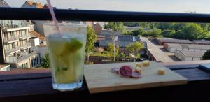 a drink and some food on a table on a balcony at Bonheur in Blankenberge