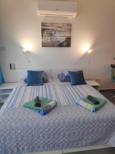 een slaapkamer met een groot bed met 2 kussens erop bij RELAX&DREAM apartment Long Beach in Saint Yeorgios