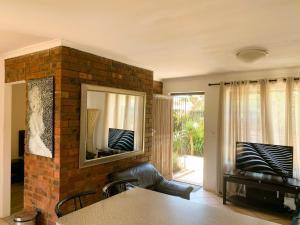 a living room with a brick wall and a mirror at Apartment with garden, and garage in Cape Town