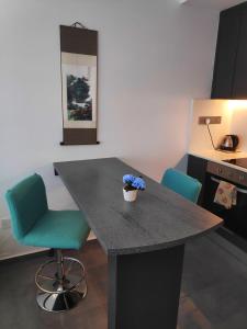 een keuken met een tafel met twee stoelen en een plant erop bij RELAX&DREAM apartment Long Beach in Saint Yeorgios