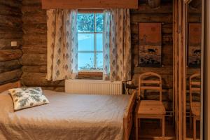 - une chambre avec un lit, une fenêtre et une chaise dans l'établissement Hillankukka, à Äkäslompolo