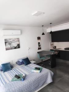 een slaapkamer met een bed met blauwe kussens en een bureau bij RELAX&DREAM apartment Long Beach in Saint Yeorgios