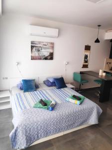 a bedroom with a bed with blue pillows and a desk at RELAX&DREAM apartment Long Beach in Saint Yeorgios