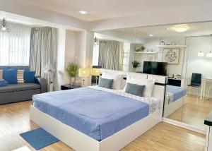 a bedroom with a bed and a living room at Cozy A at Nimman Studio Room in Condominium in Chiang Mai