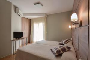 ein Hotelzimmer mit 2 Betten und einem TV in der Unterkunft El Camí Hotel in Cambrils