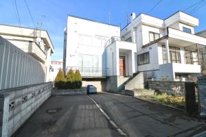 una calle vacía frente a una casa blanca en HDO Hachiken Villa, en Sapporo