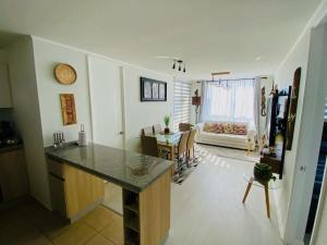 een keuken en een woonkamer met een aanrecht en een tafel bij Departamento frente a la playa full amoblado in Coquimbo