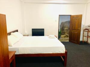 a bedroom with a large bed and a television at The Fog House in Haputale