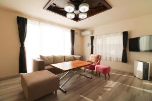 un soggiorno con tavolo e divano di HDO Hachiken Villa a Sapporo