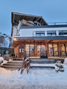 Ein Gebäude mit einem Schild, das hungrige Landeier im Schnee liest. in der Unterkunft SKILL Mountain Lodge - Ski und Bike Hostel inklusive JOKER CARD in Saalbach-Hinterglemm