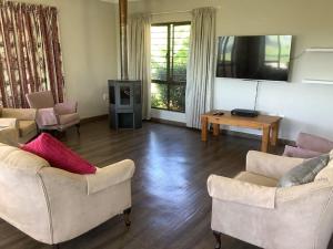 a living room with two couches and a tv at The Bell's in the Berg in Underberg