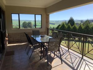 a dining room with a table and chairs on a balcony at The Bell's in the Berg in Underberg
