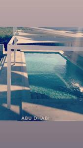 una piscina de agua junto a un edificio en My Resort en Al Rahba