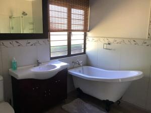 a bathroom with a tub and a sink at The Bell's in the Berg in Underberg +9 photos