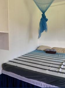 Una cama con una manta de rayas azul y blanca. en Pacific Surf and Yoga, en Baras