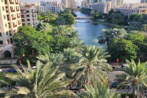 a view of a river with palm trees and buildings at Lake View The Greens & Views in Dubai