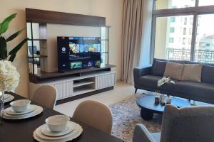 a living room with a couch and a tv at Lake View The Greens & Views in Dubai