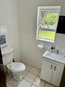 a white bathroom with a toilet and a window at Rose Cottage in Elgin in Elgin