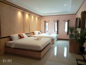 a bedroom with two beds and a couch at บีฮายฮิลล์ รีสอร์ต in Ban Khlong Kua