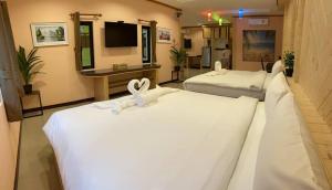 的住宿－บีฮายฮิลล์ รีสอร์ต，酒店客房,配有3张带白色床单的床