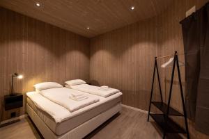 a bedroom with a bed with white pillows on it at Aurora Borealis Observatory in Silsand
