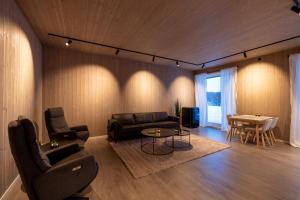 a living room with a couch and chairs and a table at Aurora Borealis Observatory in Silsand