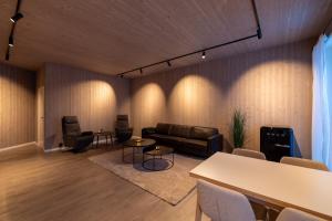 a living room with a couch and a table and chairs at Aurora Borealis Observatory in Silsand