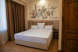 a bedroom with a bed with a drawing on the wall at KUMA Hotel Gyumri in Gyumri