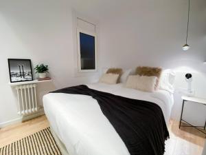 Un dormitorio blanco con una gran cama blanca. en ÜNik - Rústico & Moderno En Arinsal - ESQUÍ en Mas de Ribafeta